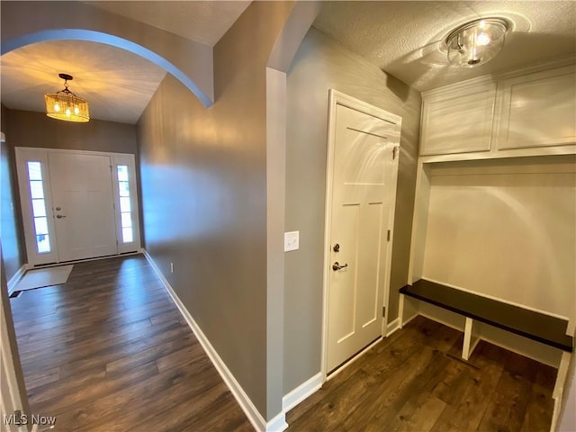 foyer entrance with a textured ceiling and dark hardwood / wood-style floors