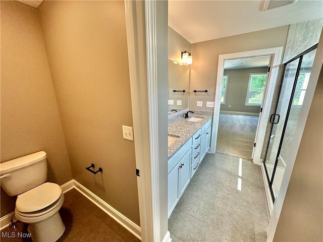 bathroom featuring an enclosed shower, vanity, and toilet