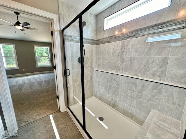 bathroom with ceiling fan, a healthy amount of sunlight, and an enclosed shower