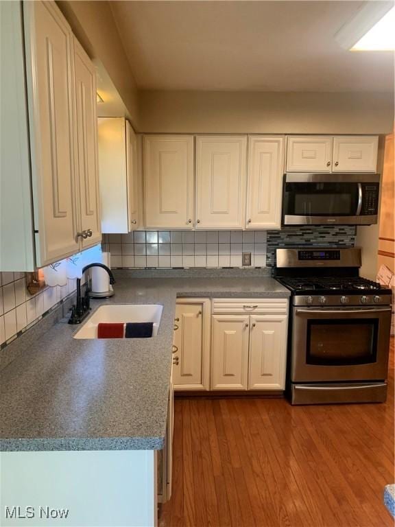 kitchen featuring sink, white cabinets, light hardwood / wood-style floors, and appliances with stainless steel finishes