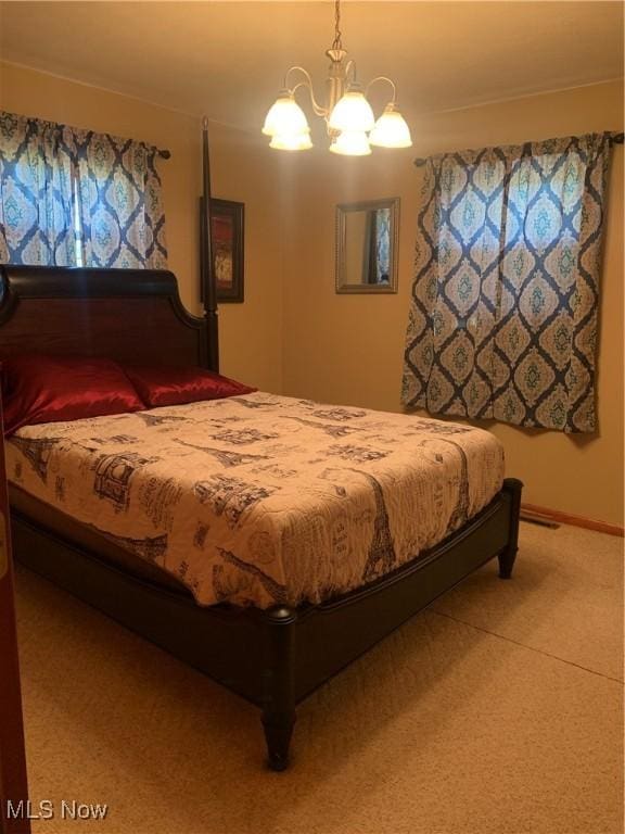 carpeted bedroom featuring an inviting chandelier