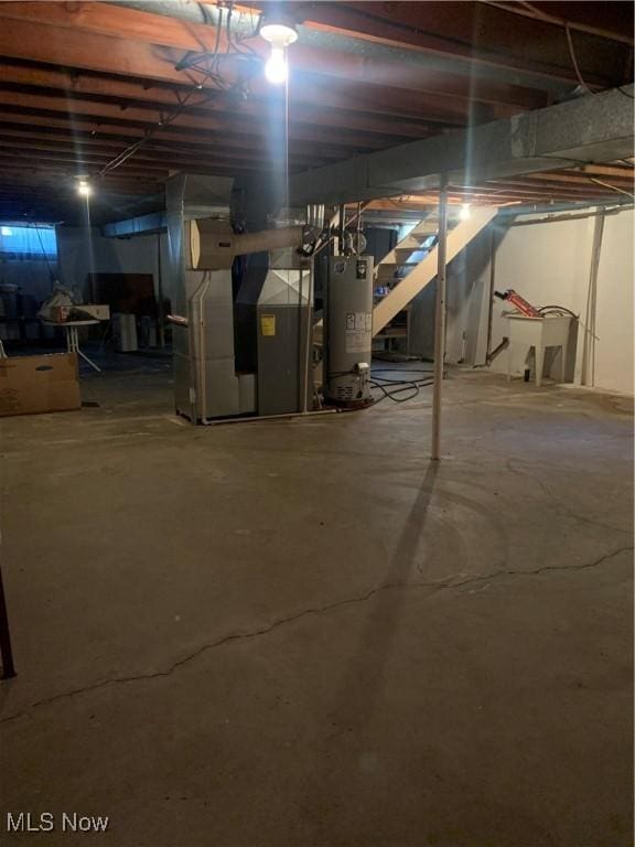 basement featuring sink, heating unit, and water heater