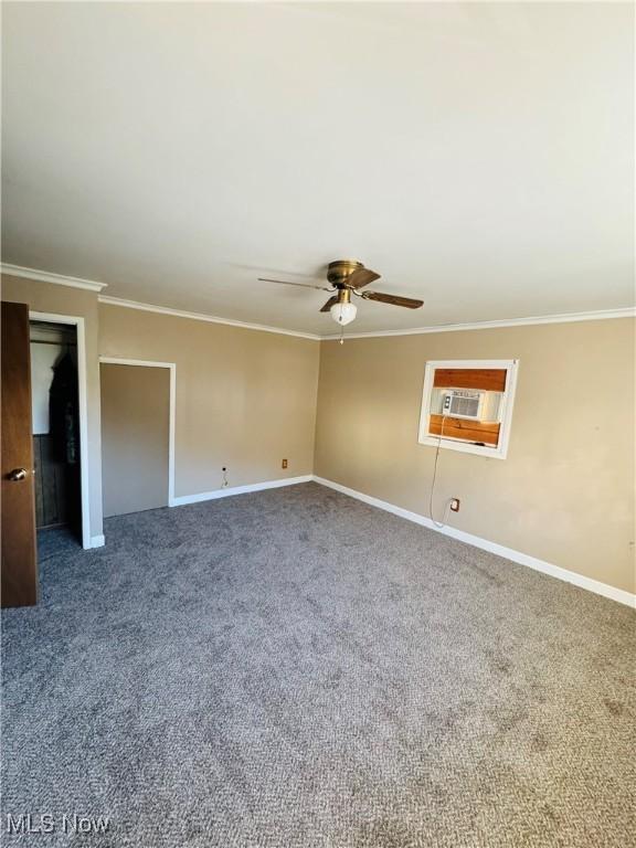 empty room featuring ceiling fan, carpet floors, and crown molding