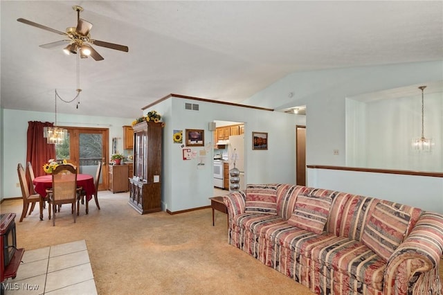 carpeted living room featuring ceiling fan with notable chandelier and vaulted ceiling