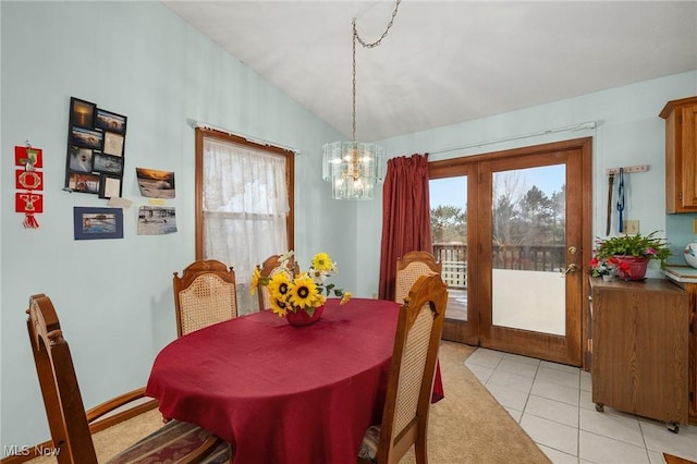 tiled dining room featuring french doors, an inviting chandelier, and lofted ceiling