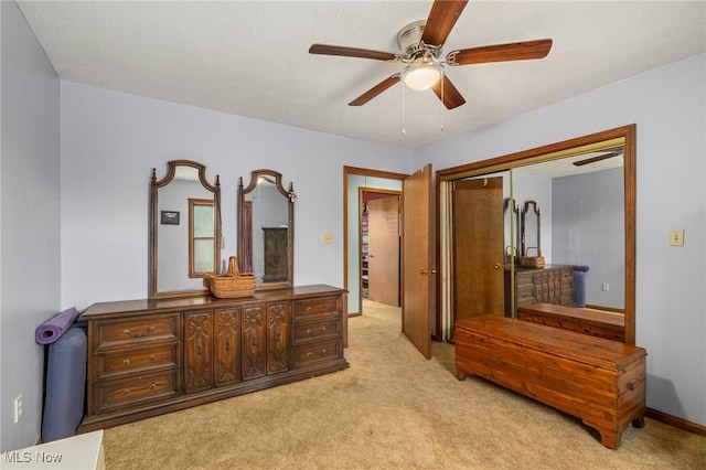 bedroom with ceiling fan, light carpet, and a closet