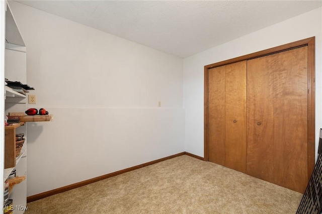 unfurnished bedroom with light carpet and a closet