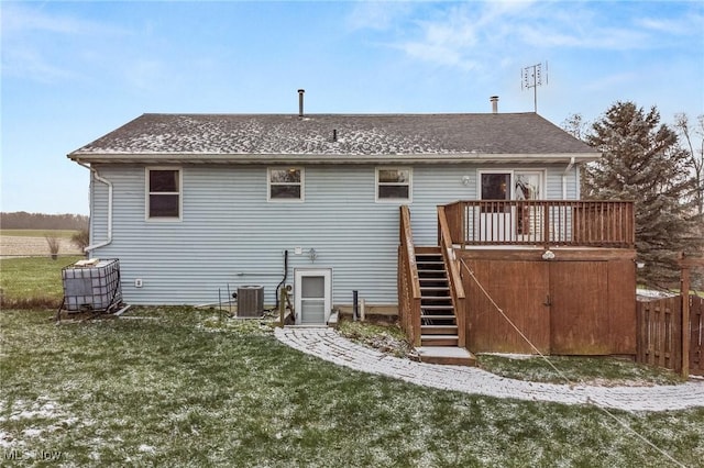 back of property featuring central air condition unit, a deck, and a lawn