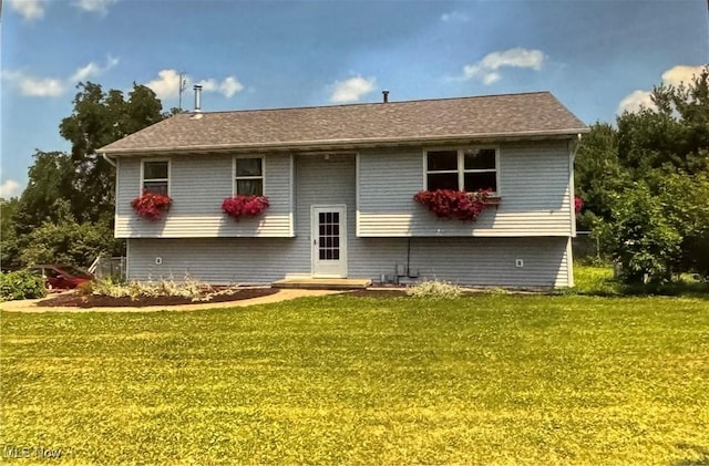 rear view of property featuring a lawn