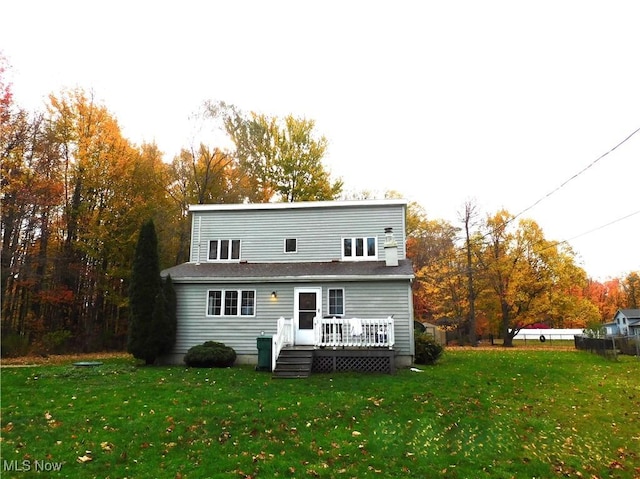 rear view of property featuring a yard and a deck