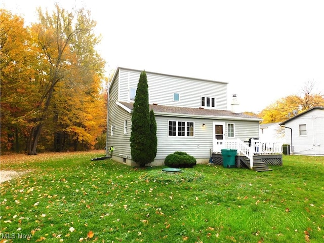 back of house featuring a lawn, a wooden deck, and central air condition unit