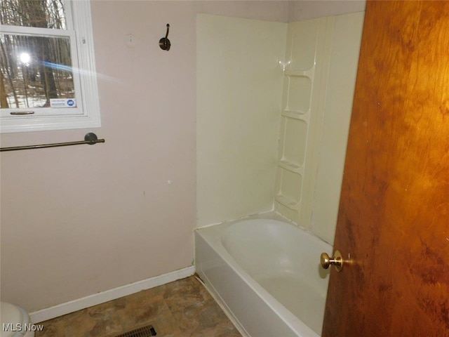 bathroom featuring shower / bath combination and toilet