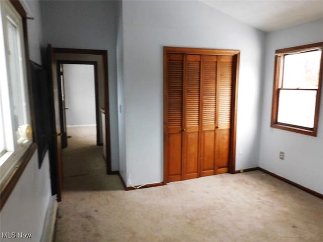 unfurnished bedroom featuring light carpet and a closet