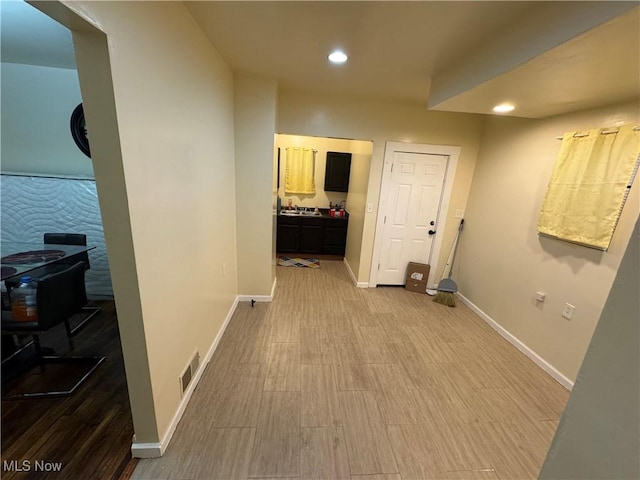 hallway featuring sink and hardwood / wood-style flooring