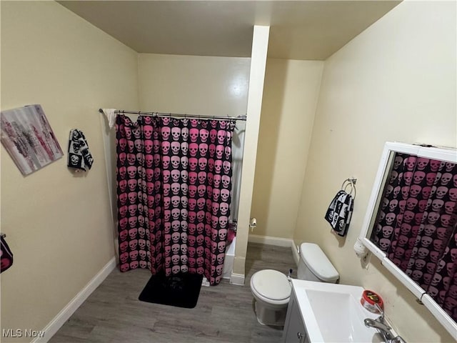 full bathroom featuring shower / bath combo with shower curtain, vanity, wood-type flooring, and toilet