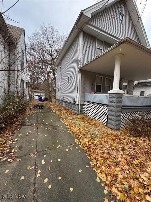 view of side of home featuring covered porch