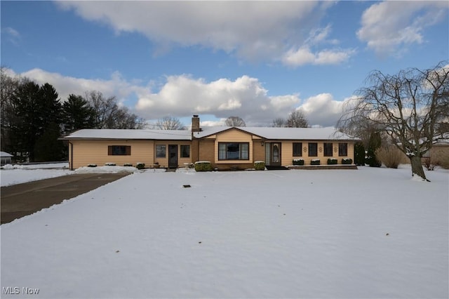 view of snow covered back of property