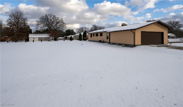 snow covered property featuring a garage