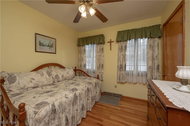 bedroom with multiple windows, light hardwood / wood-style flooring, and ceiling fan