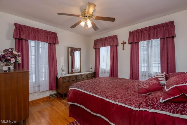 bedroom with multiple windows, light hardwood / wood-style flooring, and ceiling fan