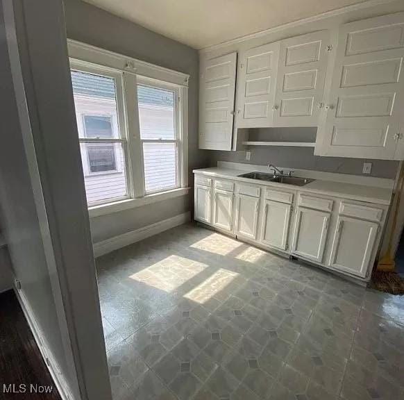 kitchen featuring white cabinetry and sink