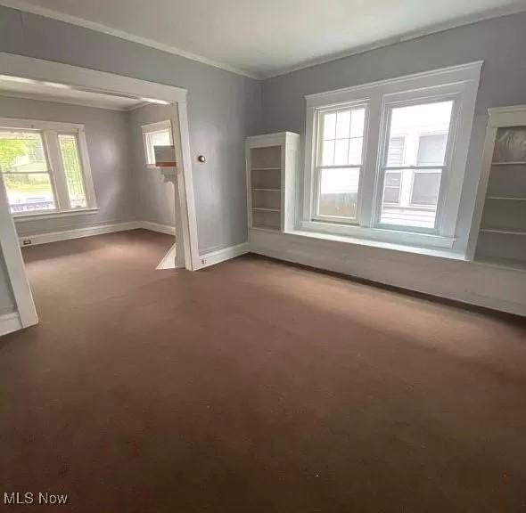 carpeted spare room with crown molding