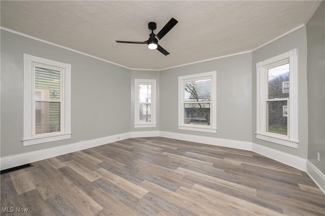 unfurnished room with a wealth of natural light, a textured ceiling, and hardwood / wood-style flooring