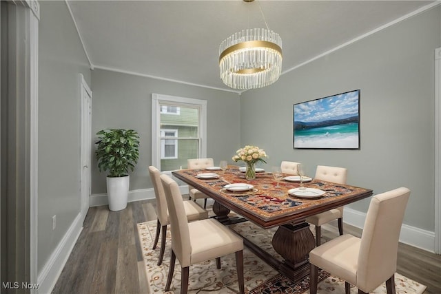 dining area featuring dark hardwood / wood-style floors, ornamental molding, and a chandelier