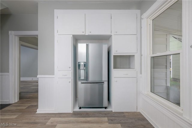 kitchen featuring white cabinets, stainless steel fridge with ice dispenser, and light hardwood / wood-style flooring