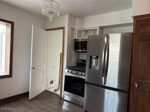 kitchen with appliances with stainless steel finishes, dark hardwood / wood-style floors, and a notable chandelier