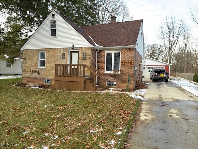 view of front of house with a garage, a front lawn, and an outbuilding