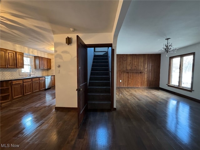 interior space with plenty of natural light, dark hardwood / wood-style floors, sink, and an inviting chandelier