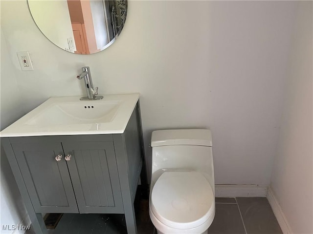 bathroom featuring toilet, vanity, and tile patterned flooring