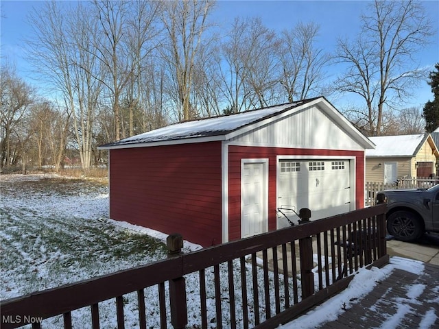 snow covered structure with a garage