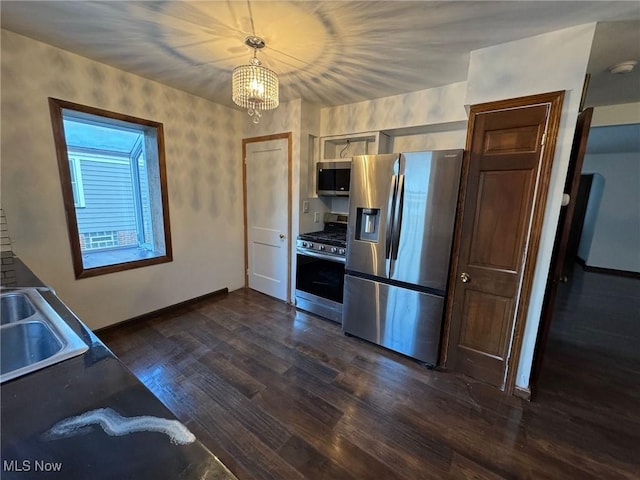 kitchen featuring dark hardwood / wood-style flooring, stainless steel appliances, sink, hanging light fixtures, and a chandelier