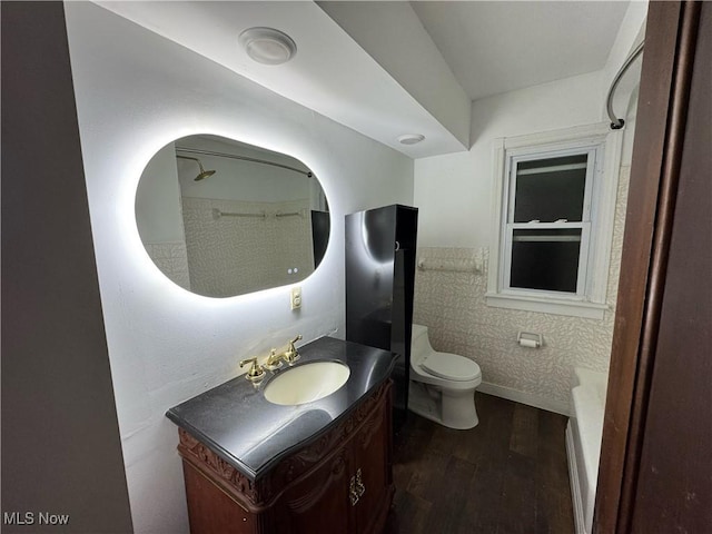 bathroom with toilet, vanity, and hardwood / wood-style floors