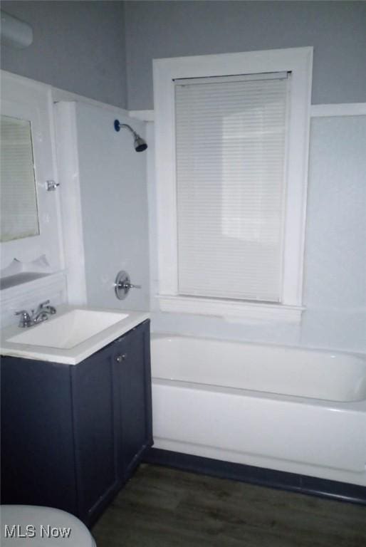 bathroom featuring hardwood / wood-style floors, vanity, and tub / shower combination