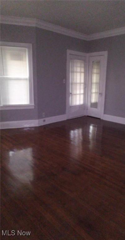 empty room with crown molding and hardwood / wood-style floors