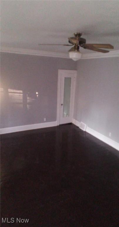 spare room featuring ceiling fan and ornamental molding