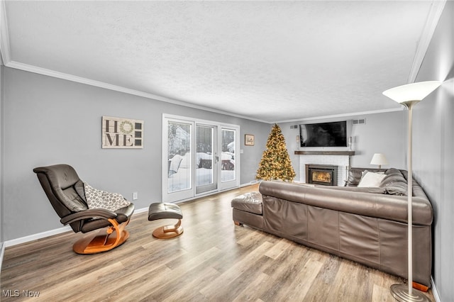 living room featuring hardwood / wood-style floors, ornamental molding, and a textured ceiling