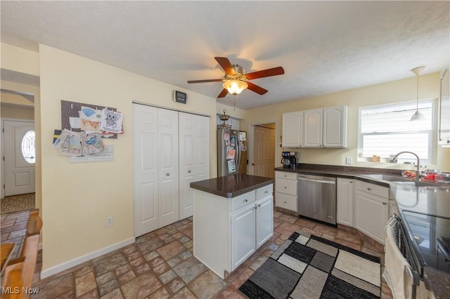 kitchen with stainless steel appliances, ceiling fan, sink, white cabinets, and a kitchen island