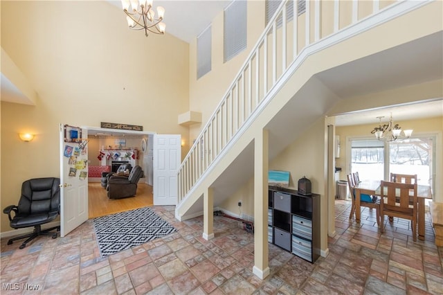 entryway featuring a towering ceiling and a chandelier