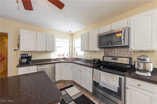 kitchen with sink, white cabinets, and appliances with stainless steel finishes