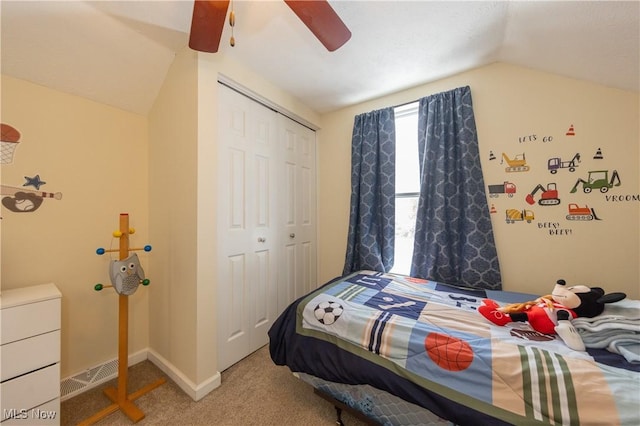 carpeted bedroom featuring ceiling fan, a closet, and vaulted ceiling