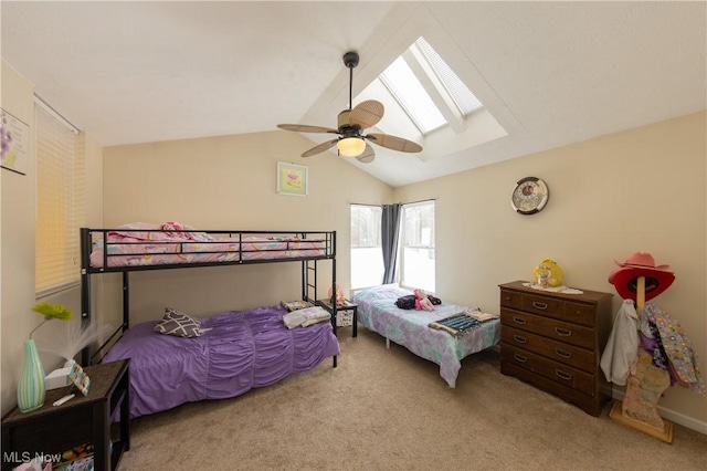 bedroom featuring light carpet, lofted ceiling with skylight, and ceiling fan