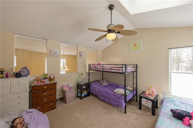 bedroom with ceiling fan, lofted ceiling with skylight, and light carpet