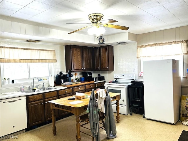 kitchen featuring sink, white appliances, dark brown cabinets, and ceiling fan