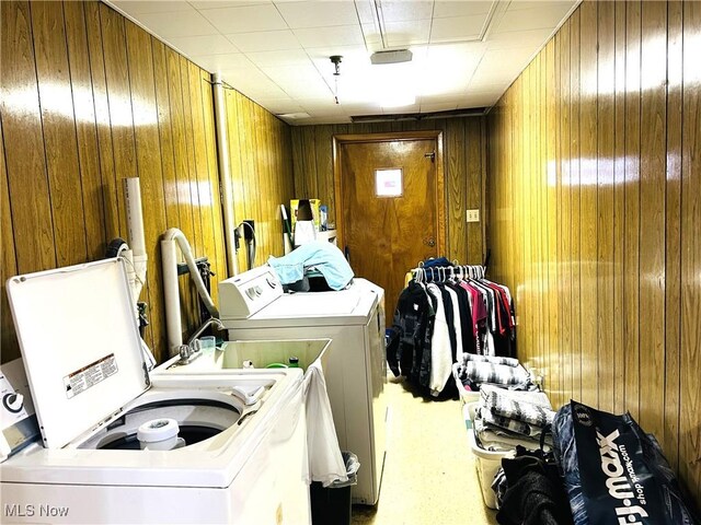 washroom with wooden walls and separate washer and dryer