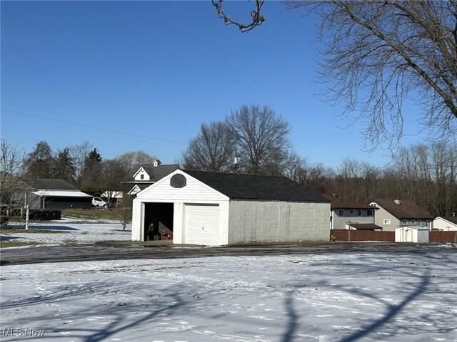 snow covered structure featuring a garage