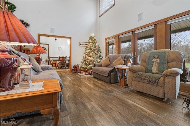 living room featuring french doors, a towering ceiling, and hardwood / wood-style flooring